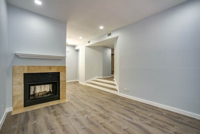 Unfurnished living room with a tile fireplace, wood finished floors, and recessed lighting | Image 8