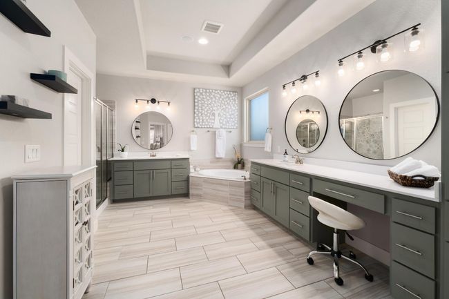 Luxurious master bathroom featuring a tray ceiling, dual vanities and a makeup vanity | Image 18
