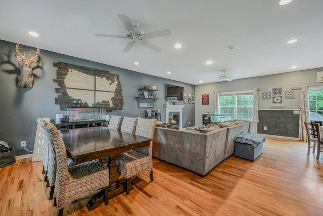 Living Area With A Warm Lit Gas Fireplace, Ceiling Fan & Recessed Lighting | Image 5