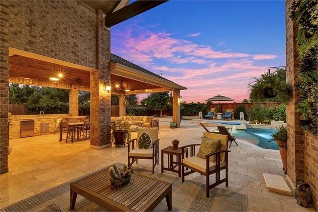 Spacious covered patio, outdoor kitchen featuring large gas grill, refrigerator, sink and stainless drawers and level 3 high-grade granite countertop — perfect for relaxing. | Image 39