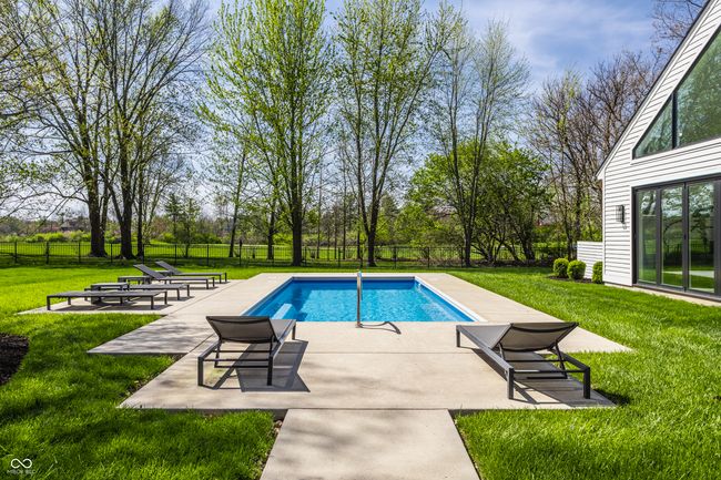 view of swimming pool with a fenced backyard, a patio area, a lawn, and a fenced in pool | Image 65