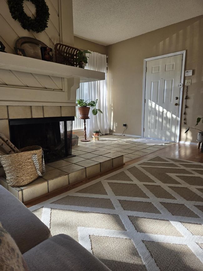 Living area with a fireplace and a textured ceiling | Image 10