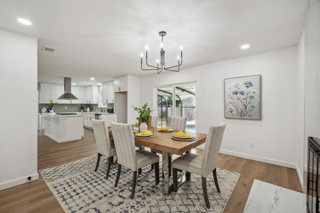 Dining room with a chandelier, baseboards, light wood finished floors, and recessed lighting | Image 9
