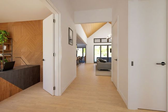 Hallway offers a view of the vaulted ceiling in the Great Room, adding depth and architectural interest. | Image 4