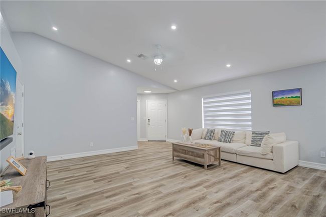Living room featuring vaulted ceiling, light wood-style flooring, recessed lighting, baseboards, and a ceiling fan | Image 6