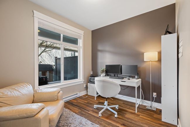 Office area with wood finished floors, a baseboard heating unit, and baseboards | Image 32