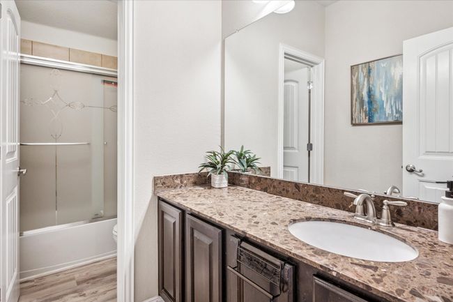 Full bath with wood finished floors, vanity, combined bath / shower with glass door, and toilet | Image 21
