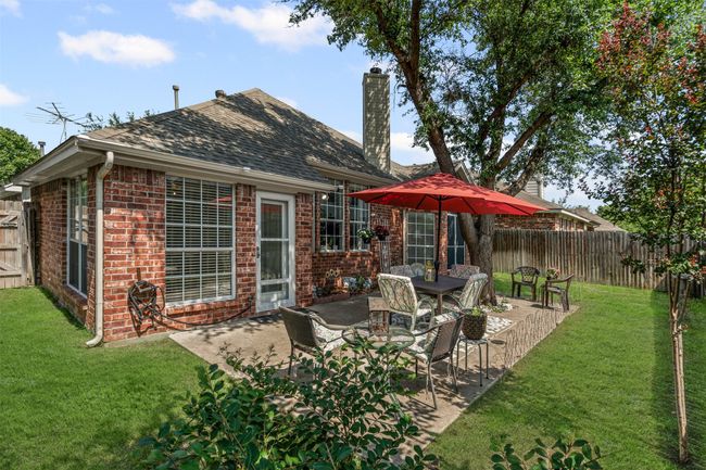 Rear view of house with brick siding, a patio area, and a chimney | Image 24