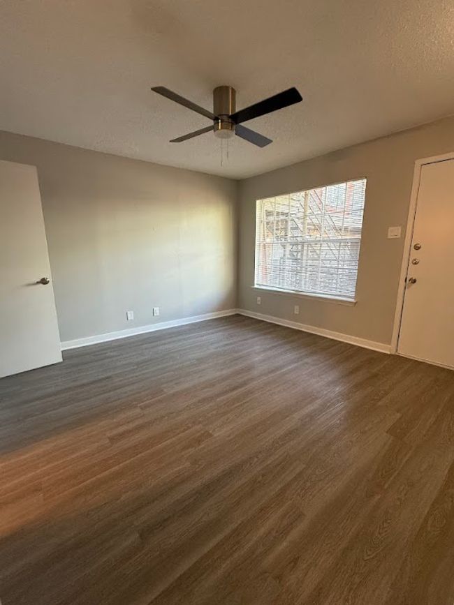 Spare room featuring dark wood-type flooring, ceiling fan, baseboards, and a textured ceiling | Image 19
