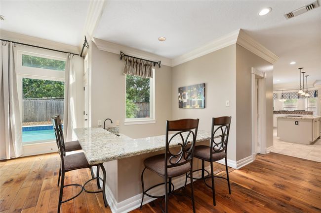 Just steps from the patio door, this interior wet bar with seating adds a touch of fun and function—ideal for weekend get-togethers, poolside refreshments, or relaxed evenings in. | Image 13