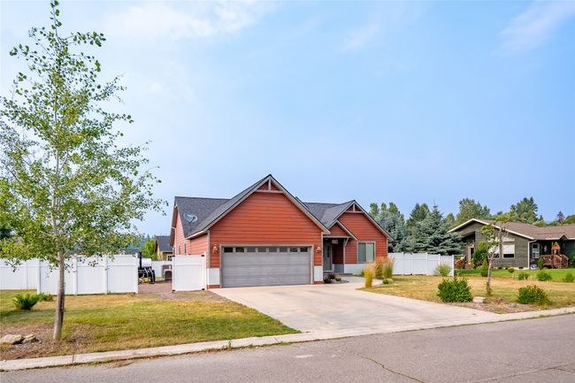View of front of house with a garage, driveway, fence, and a front lawn | Image 16
