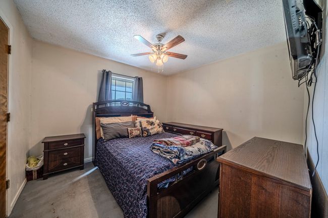 Bedroom with carpet floors, a textured ceiling, and ceiling fan | Image 21