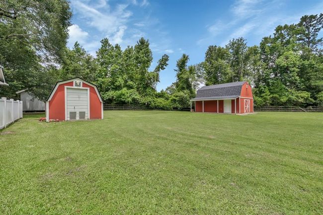 ~1 Acre with dividing fence on the far left. Building on the left houses the pool equipment.Behind that is another bigger shed for your storage needs. Barn is on the right. | Image 48