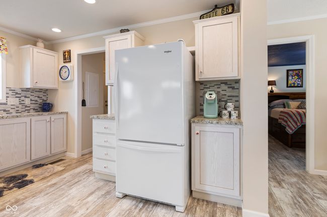 kitchen with freestanding refrigerator, tasteful backsplash, recessed lighting, crown molding, and light wood finished floors | Image 18