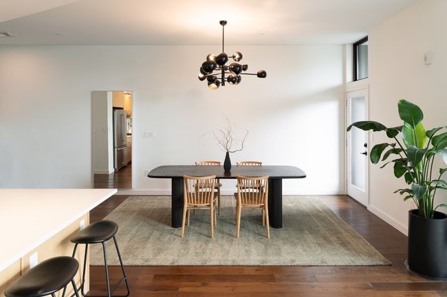 Dining area with dark wood-type flooring, baseboards, and a chandelier | Image 9