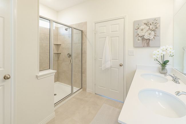 Full bathroom featuring a sink, tile patterned flooring, double vanity, and tiled shower | Image 10