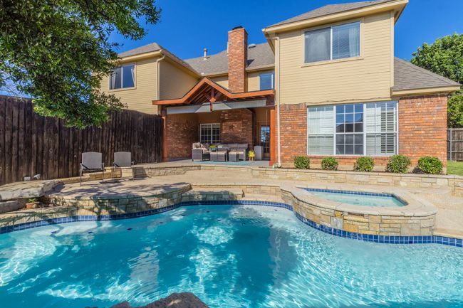 View of swimming pool with a pool with connected hot tub and a patio | Image 35