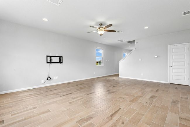 Unfurnished living room featuring ceiling fan, light wood finished floors, and recessed lighting | Image 8