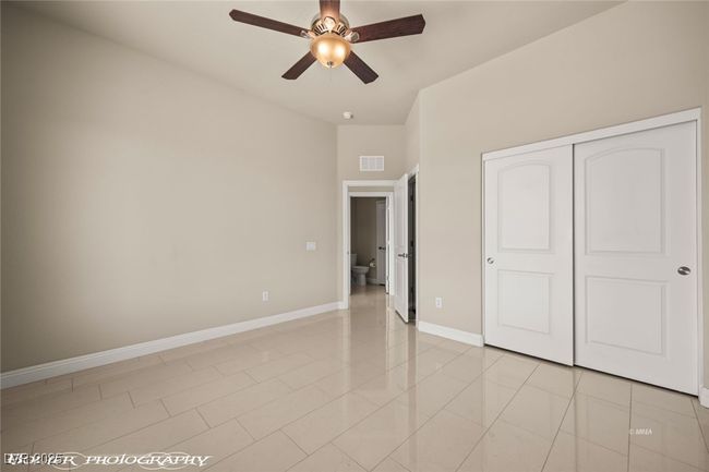 Unfurnished bedroom featuring a closet, baseboards, ceiling fan, and visible vents | Image 39