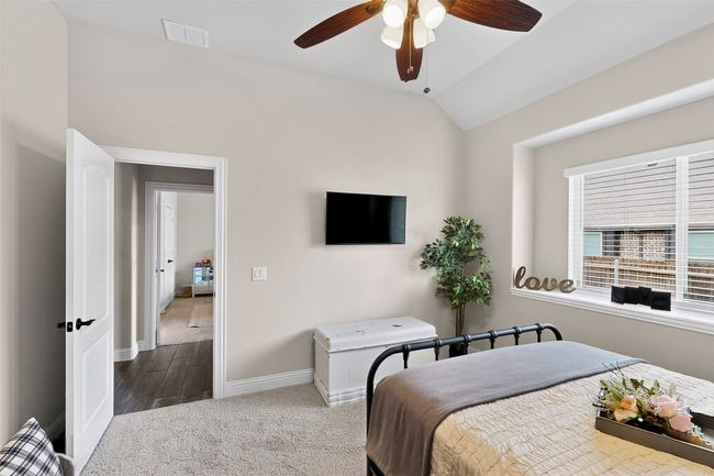 Carpeted bedroom with baseboards, lofted ceiling, ceiling fan, and wood finished floors | Image 25