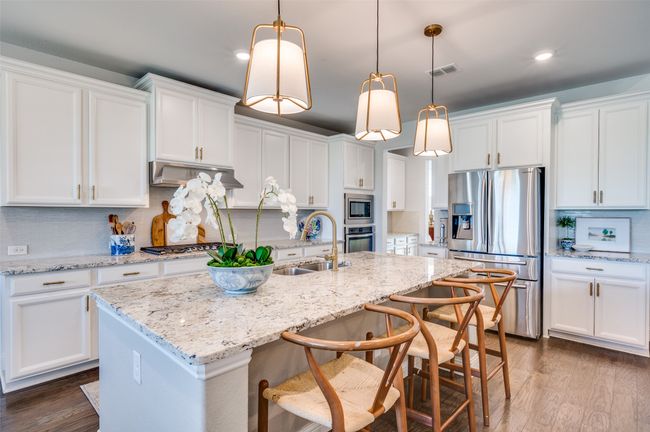 This gorgeous kitchen features upgraded granite countertops, upgraded pendant lighting and breakfast bar island. | Image 9