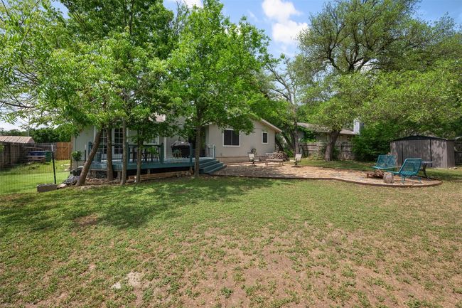 View of yard with a fire pit, a wooden deck, an outbuilding, and a fenced backyard | Image 29