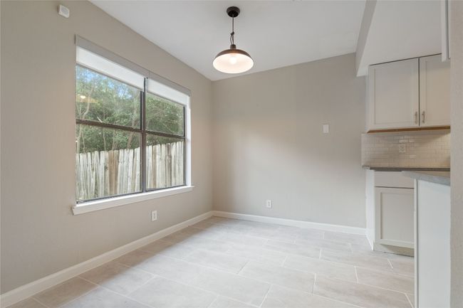 Sunny dining area just off the kitchen with large window overlooking the private fenced yard — ideal for morning coffee or dinner with friends. | Image 9