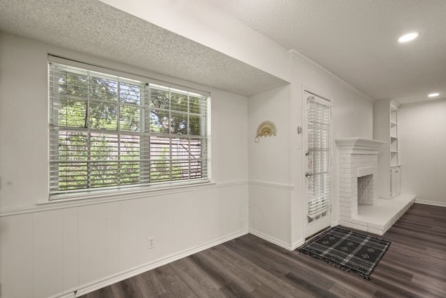 Unfurnished living room with plenty of natural light, a brick fireplace, and dark wood finished floors | Image 10