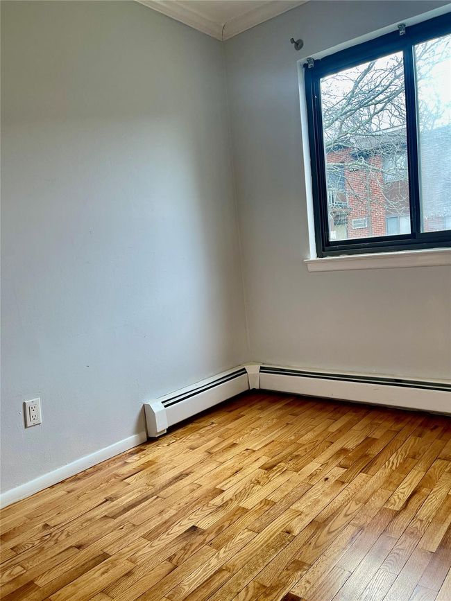 Spare room featuring light wood-style flooring, crown molding, and baseboards | Image 8