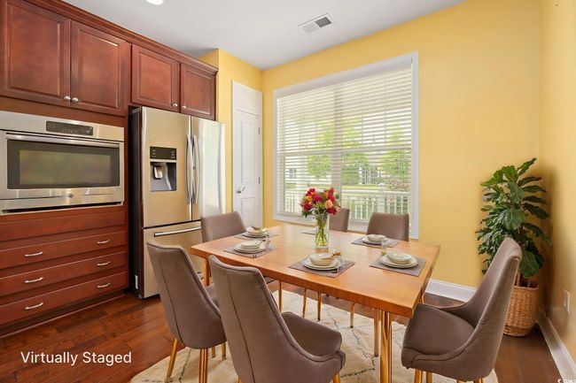 Dining area featuring visible vents, dark wood-style flooring, and baseboards | Image 6