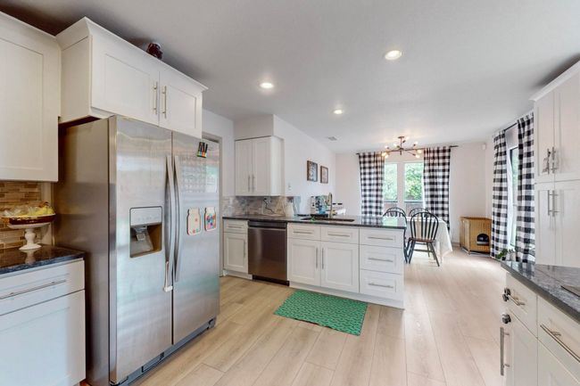 Kitchen featuring decorative backsplash, white cabinets, stainless appliances | Image 10