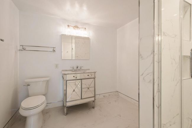 Bathroom with tiles, vanity, and a marble finish shower | Image 12
