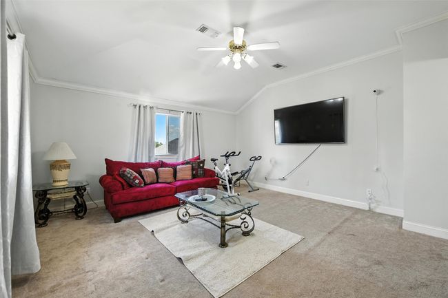 Living room featuring ornamental molding, lofted ceiling, carpet, and ceiling fan | Image 18
