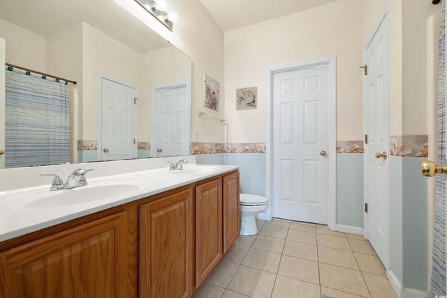 Bathroom with tile patterned floors, toilet, and double vanity | Image 21