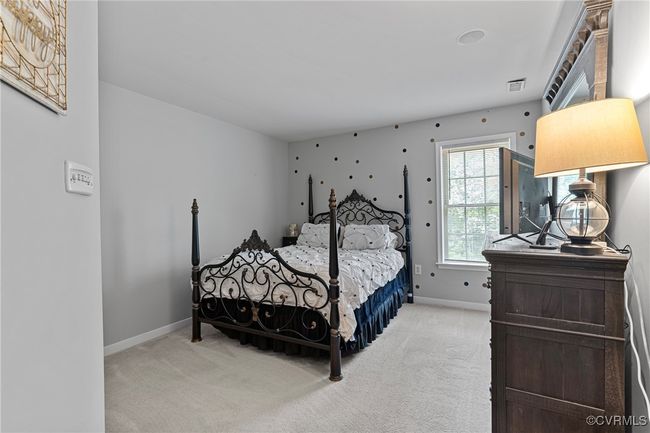 Bedroom featuring baseboards, visible vents, and light colored carpet | Image 37