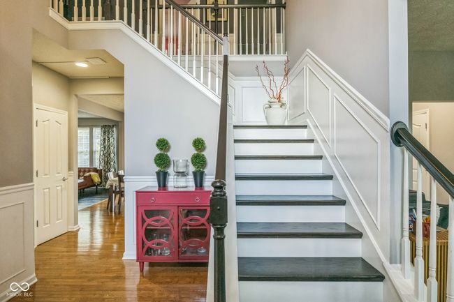 stairs featuring wood finished floors, a high ceiling, a wainscoted wall, and a decorative wall | Image 17