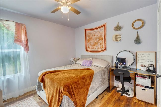 Bedroom with wood finished floors and ceiling fan | Image 11