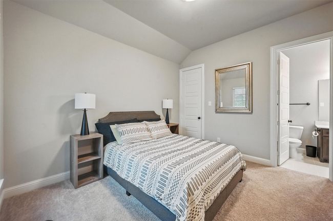 Bedroom featuring light carpet, vaulted ceiling, and connected bathroom | Image 8
