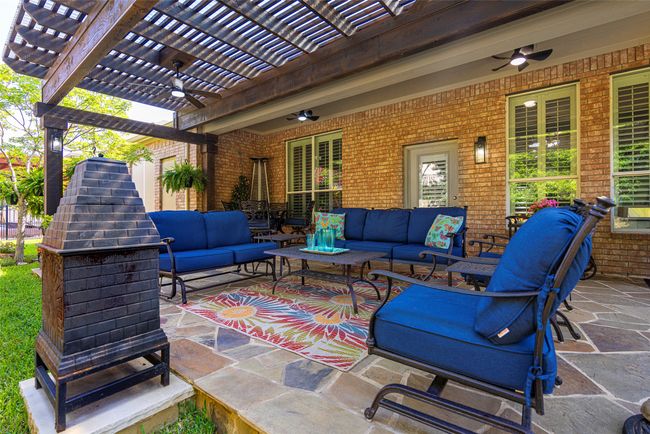 Fenced backyard featuring a pergola, an outdoor hangout area, ceiling fan, perfect for relaxing and entertaining. | Image 26