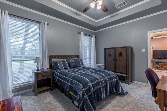 Bedroom with carpeted floors, crown molding, and ceiling fan | Image 28