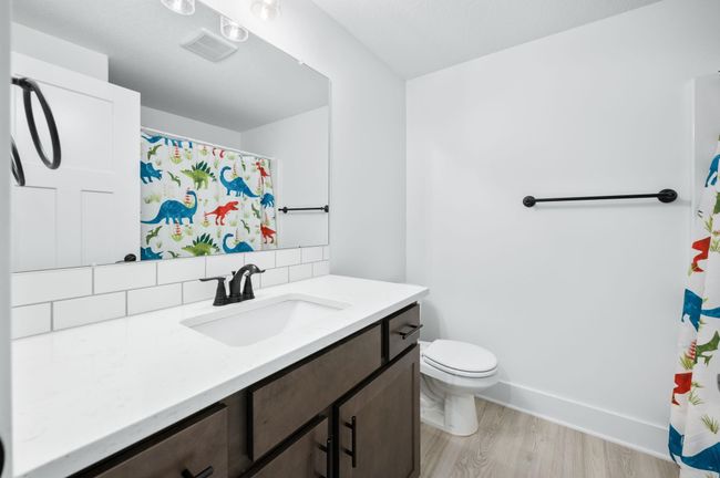 Full bathroom featuring vanity, tasteful backsplash, wood finished floors, toilet, and baseboards | Image 29