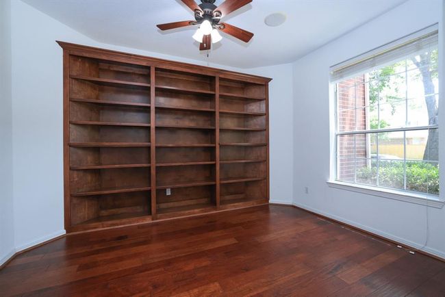 Study or formal living room with stained wood built in bookcase. Built in speakers in the ceiling. Blinds. | Image 6