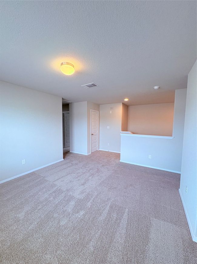 Empty room with a textured ceiling, carpet, visible vents, and baseboards | Image 26