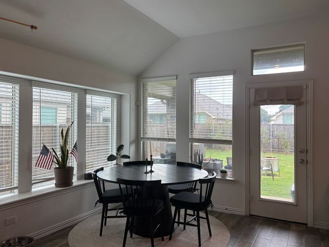 Dining space featuring vaulted ceiling, wood finished floors, and plenty of natural light | Image 11