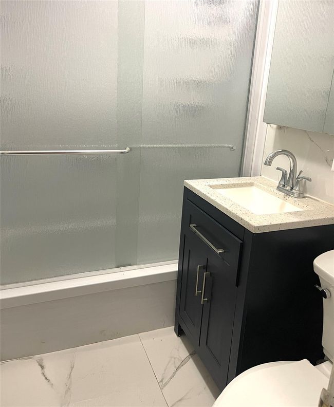Bathroom featuring marble finish floor, toilet, shower / bath combination, and vanity | Image 5