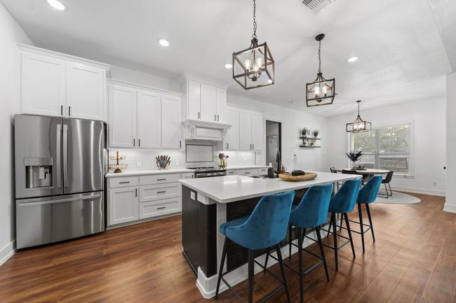 Kitchen with a chandelier, recessed lighting, visible vents, and appliances with stainless steel finishes | Image 7