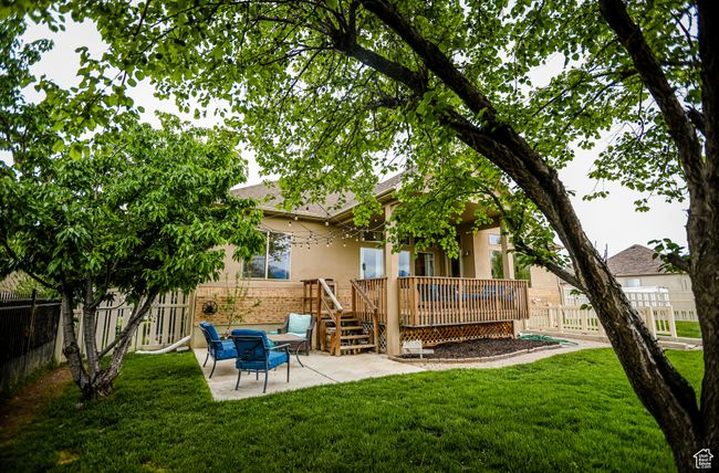 Back of property featuring a patio area, stucco siding, a wooden deck, and brick siding | Image 49
