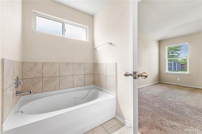 Full bathroom featuring a bath and baseboards | Image 14