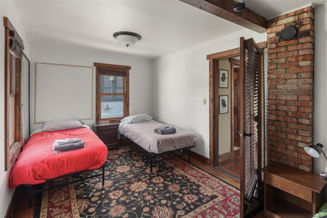 Bedroom with wood finished floors and beamed ceiling | Image 21