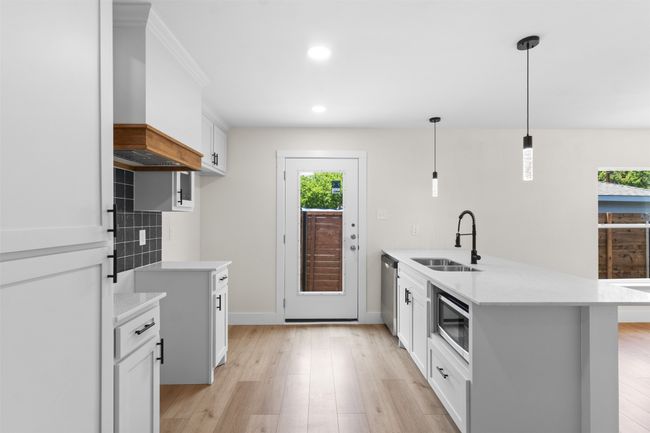 Kitchen featuring a peninsula, stainless steel appliances, plenty of natural light, light countertops, and recessed lighting | Image 18